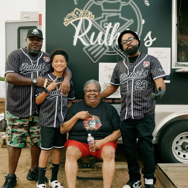 Four people, three men and one woman, pose in front of the Ruthie's food truck.